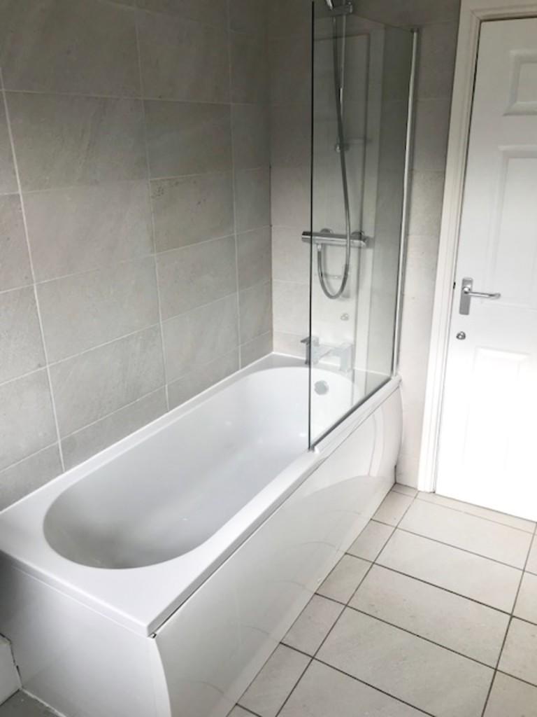 Bright and modern bathroom suite featuring a cl...
