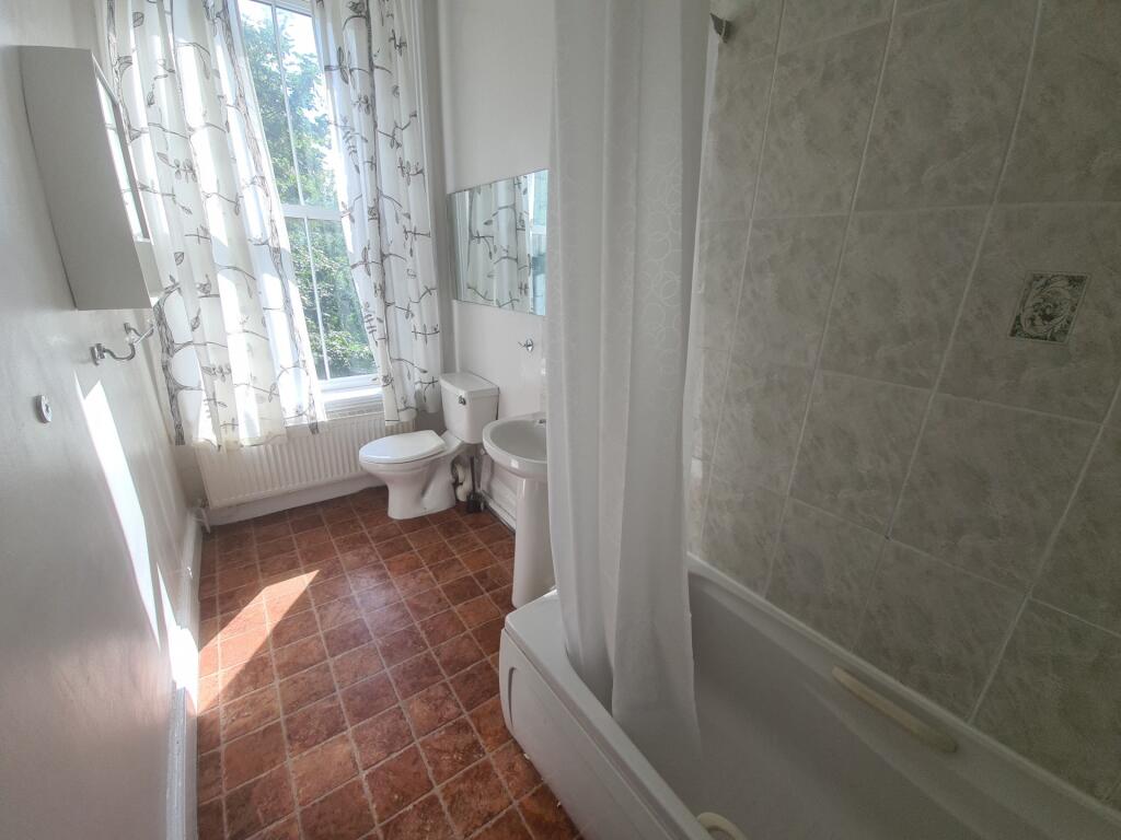 A bright, well-maintained bathroom with a large...