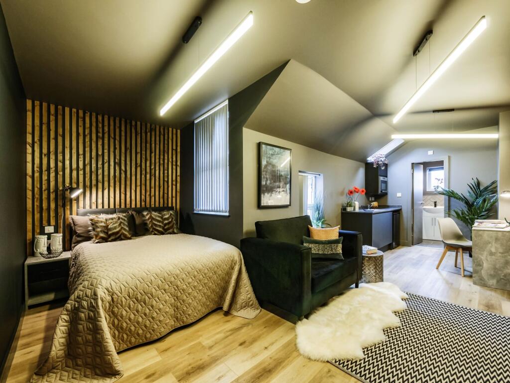 A stylish and spacious master bedroom featuring...