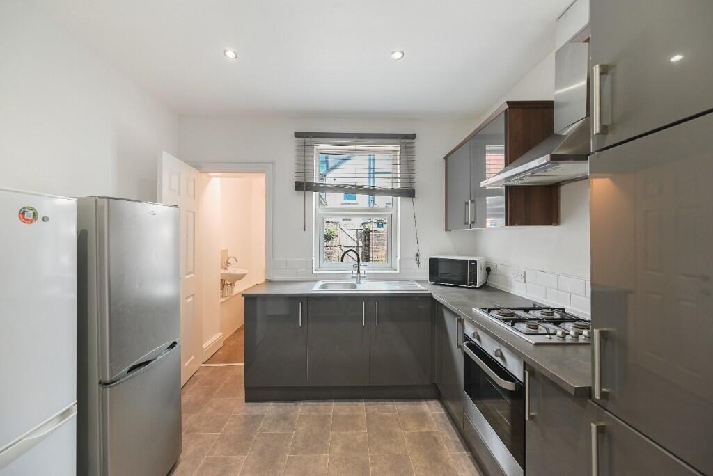 Modern kitchen featuring sleek grey cabinetry, ...