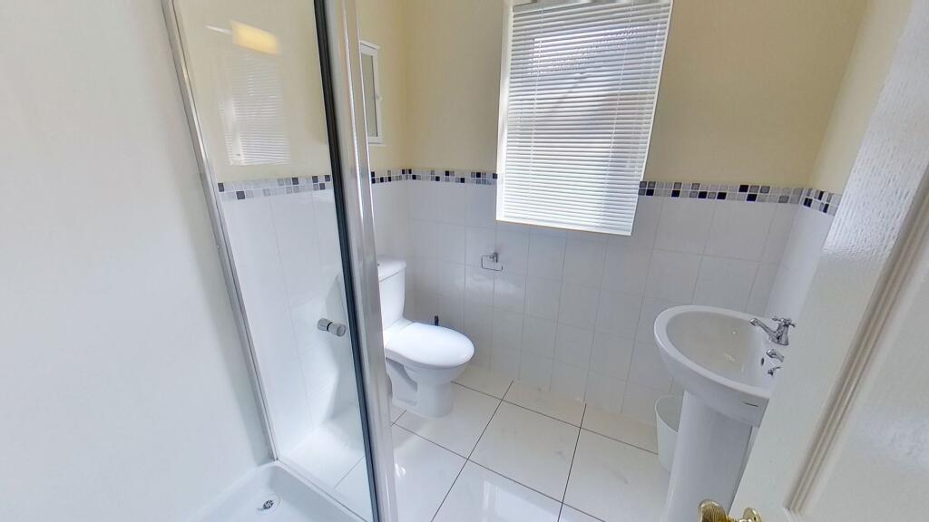 Bright, modern bathroom with a tiled shower enc...