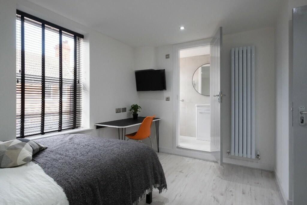 This modern double bedroom features large windo...