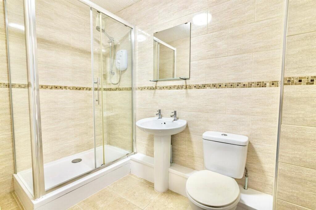 A modern bathroom featuring a spacious shower, ...