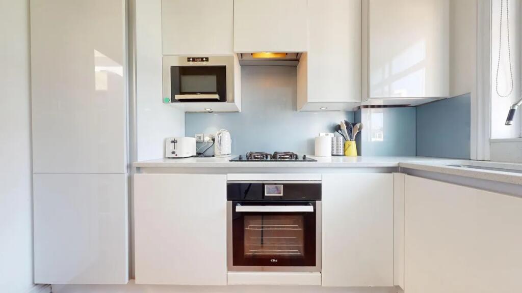Bright and modern kitchen featuring sleek white...