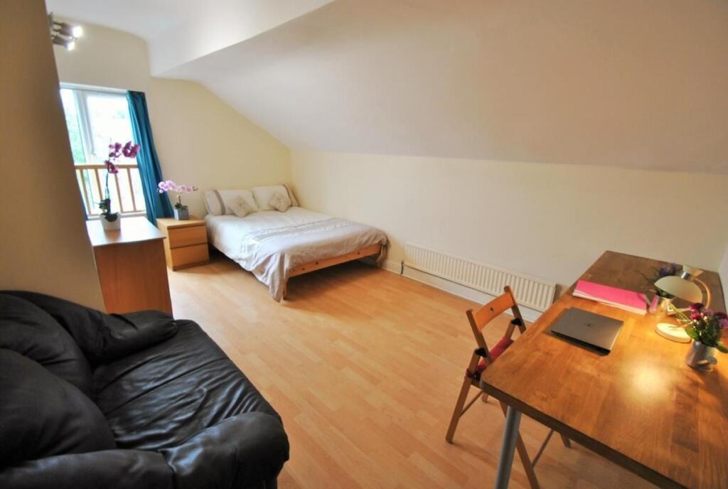 Bright attic-style double bedroom with sloped c...