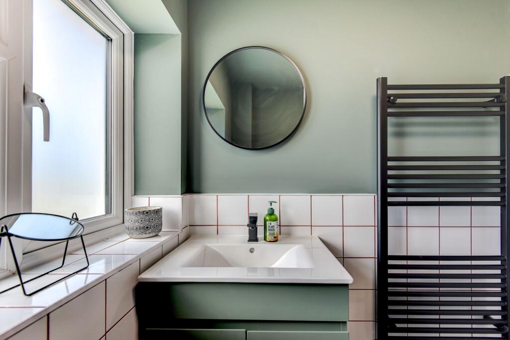 A stylish bathroom featuring a modern sink with...