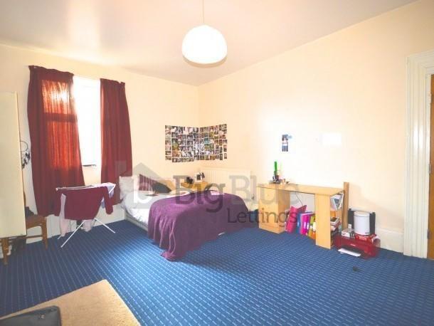 A spacious double bedroom featuring a large win...