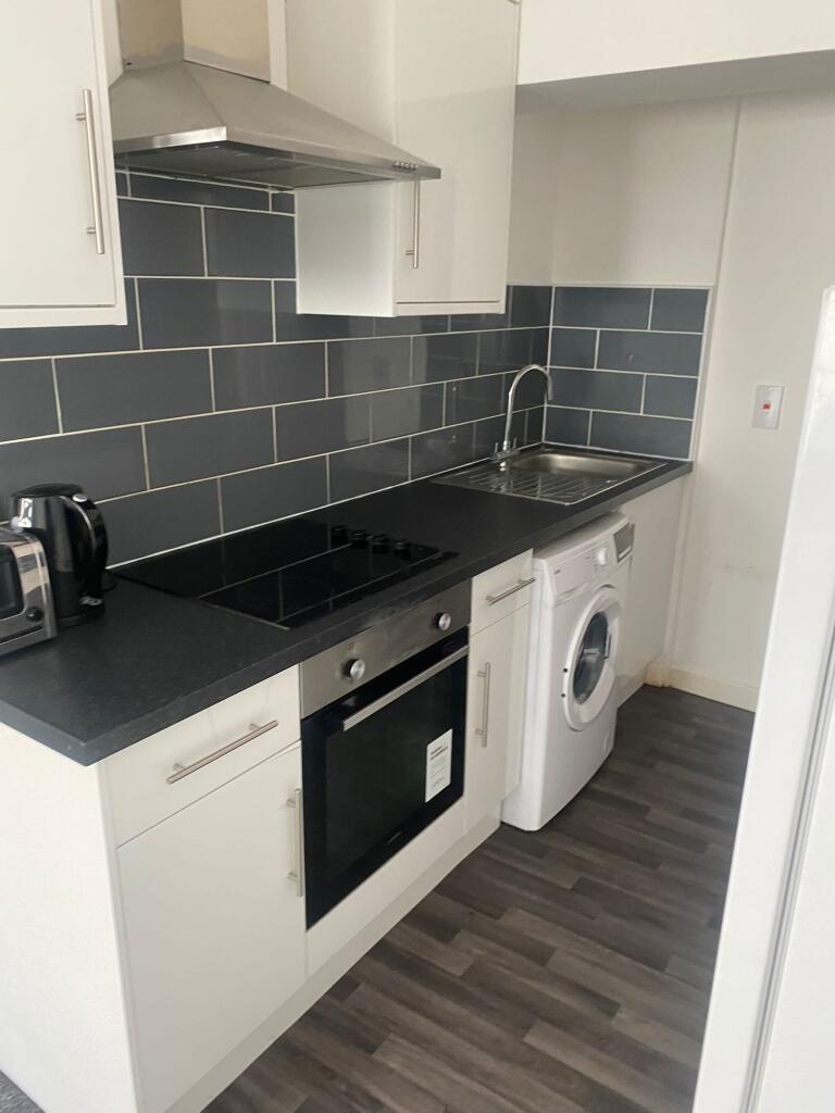 A modern kitchen with a sleek black countertop,...
