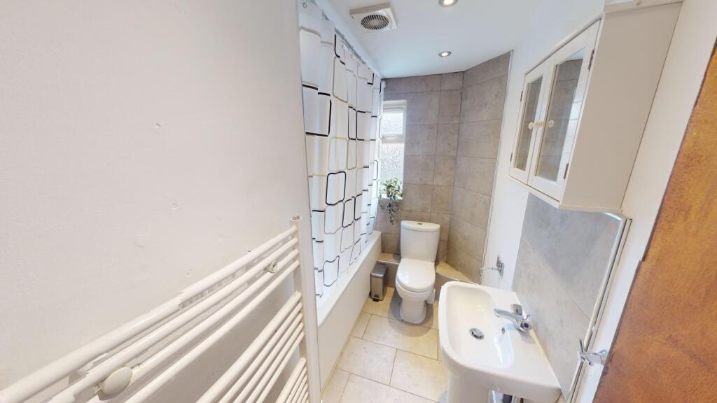 A clean and functional bathroom featuring a whi...