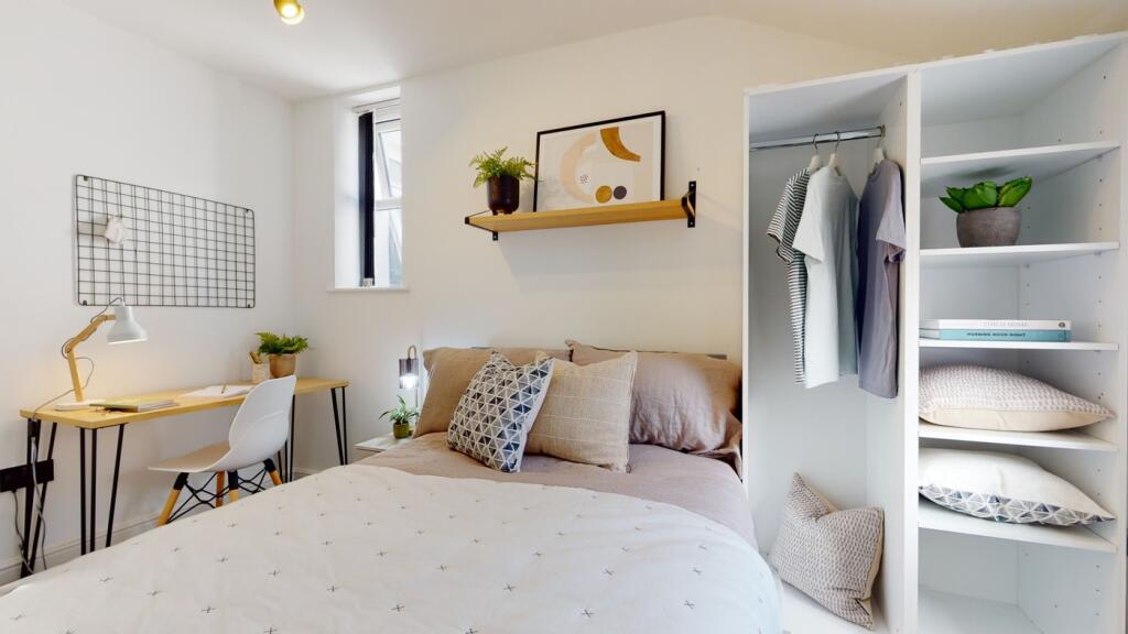 A bright and stylish double bedroom featuring a...