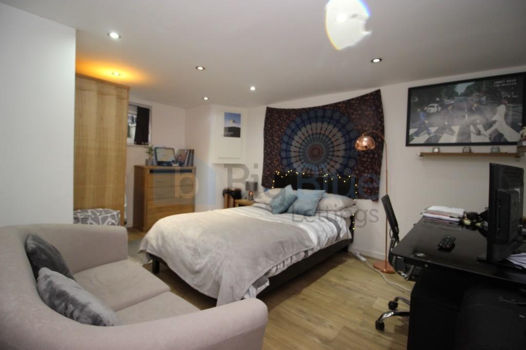 A cozy and well-organized master bedroom featur...