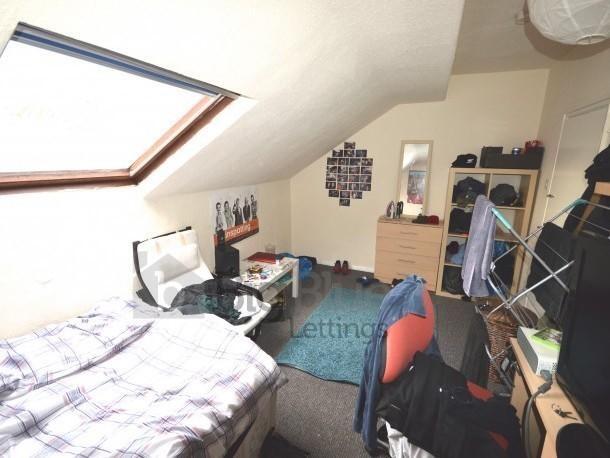 A cozy loft-style bedroom featuring a slanted s...