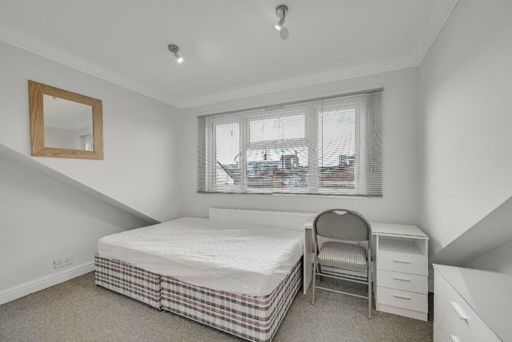 Bright double bedroom featuring a large window ...