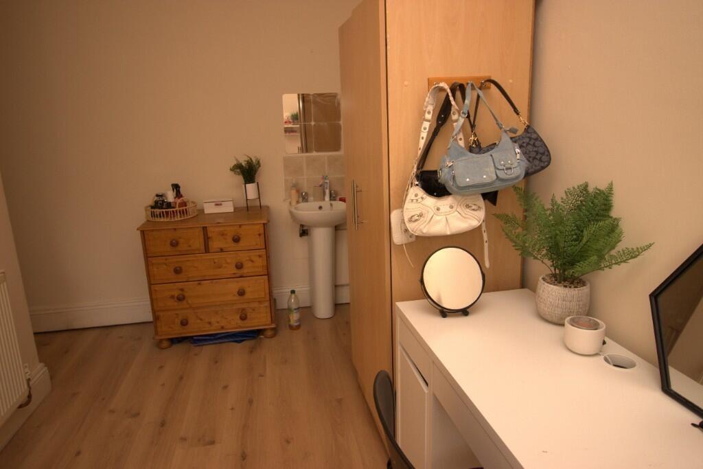 A neat hallway featuring light wooden flooring,...