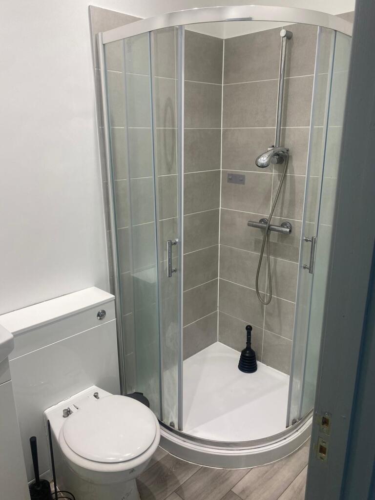 A modern bathroom featuring a spacious shower e...