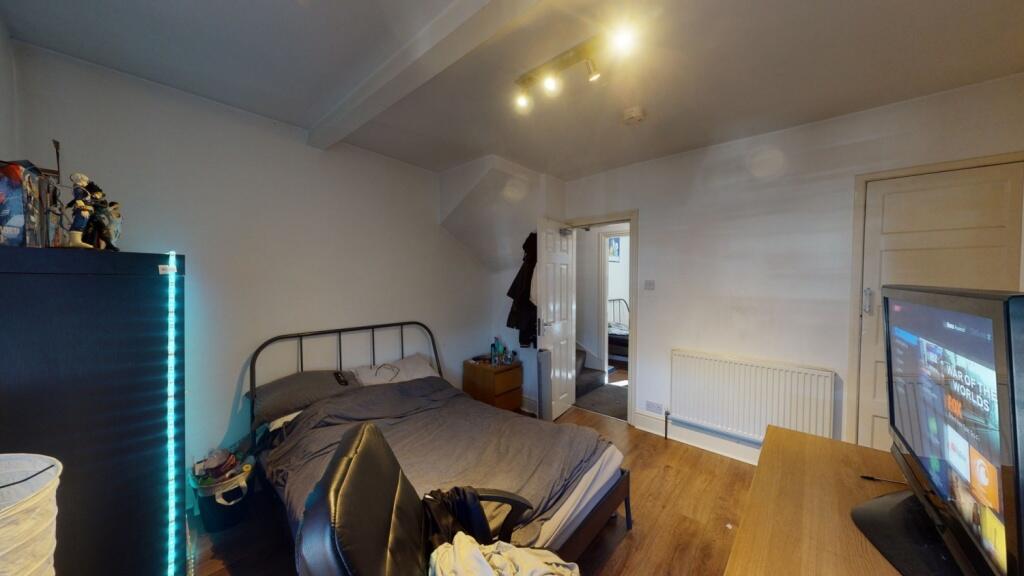 A spacious master bedroom featuring a double be...