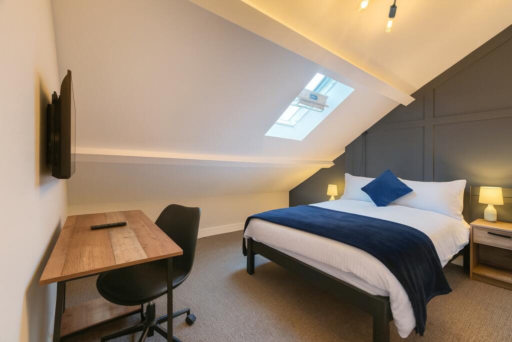 A modern, well-lit master bedroom featuring a c...