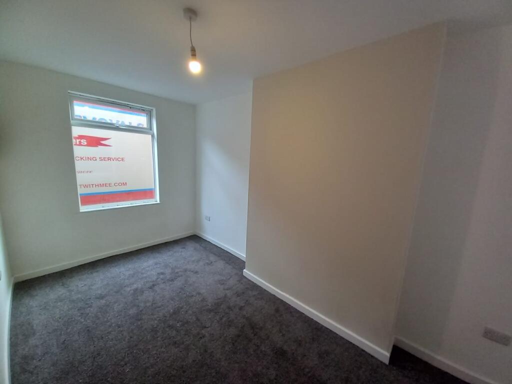 A neat and freshly painted small bedroom with d...