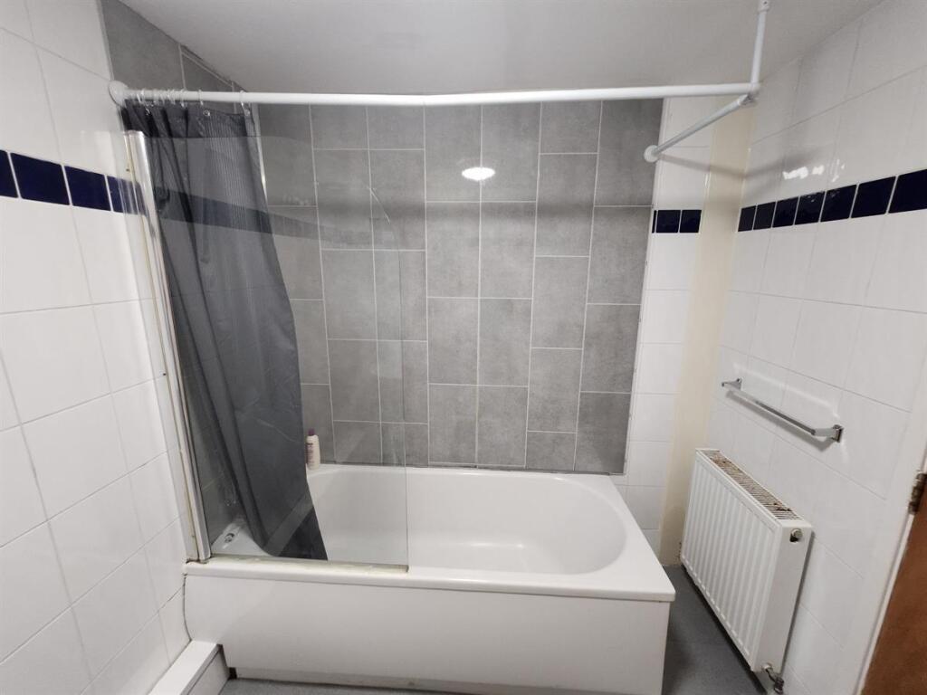 Bright and clean bathroom suite featuring a bat...