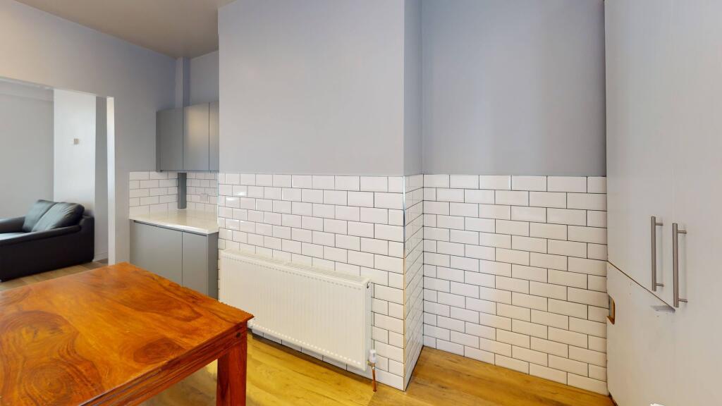 Modern kitchen area featuring white subway tile...