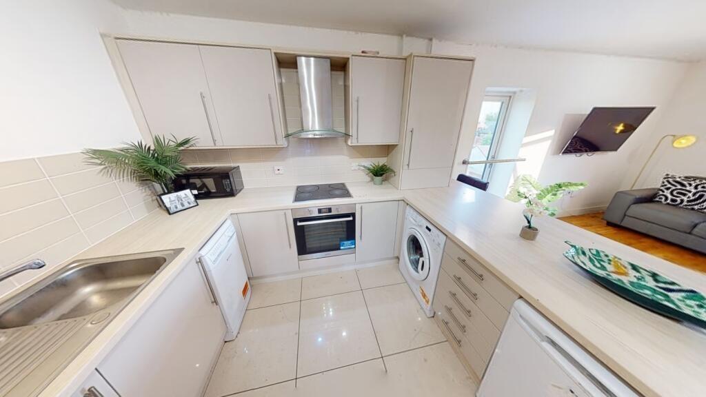 A bright and modern kitchen featuring sleek cre...