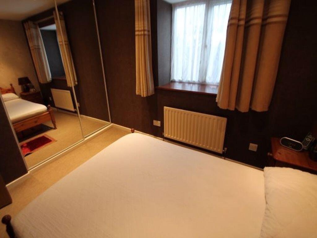 Cozy double bedroom with a comfortable bed, mir...