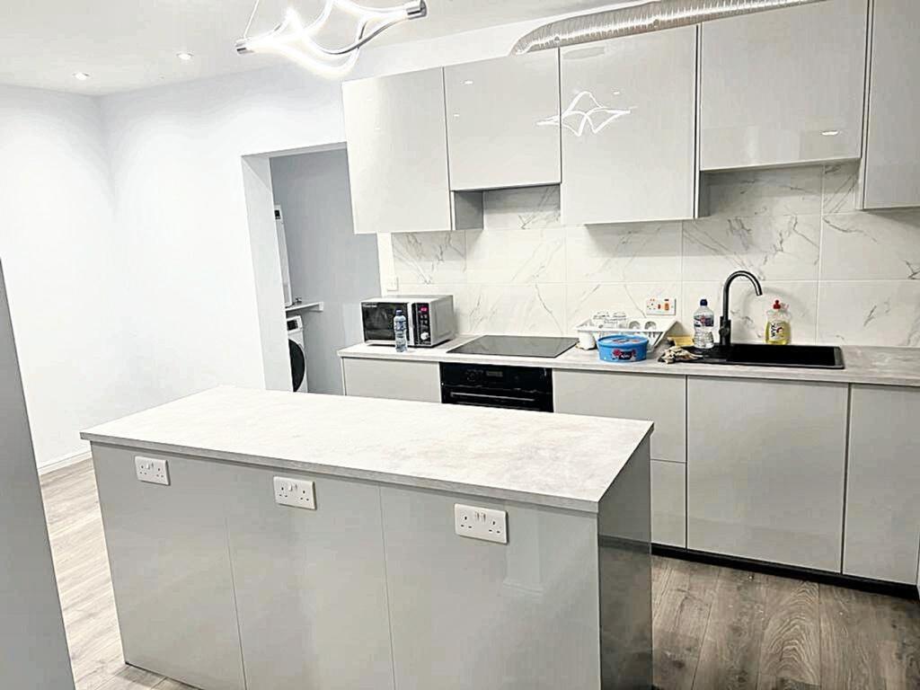 A modern and sleek kitchen featuring a spacious...