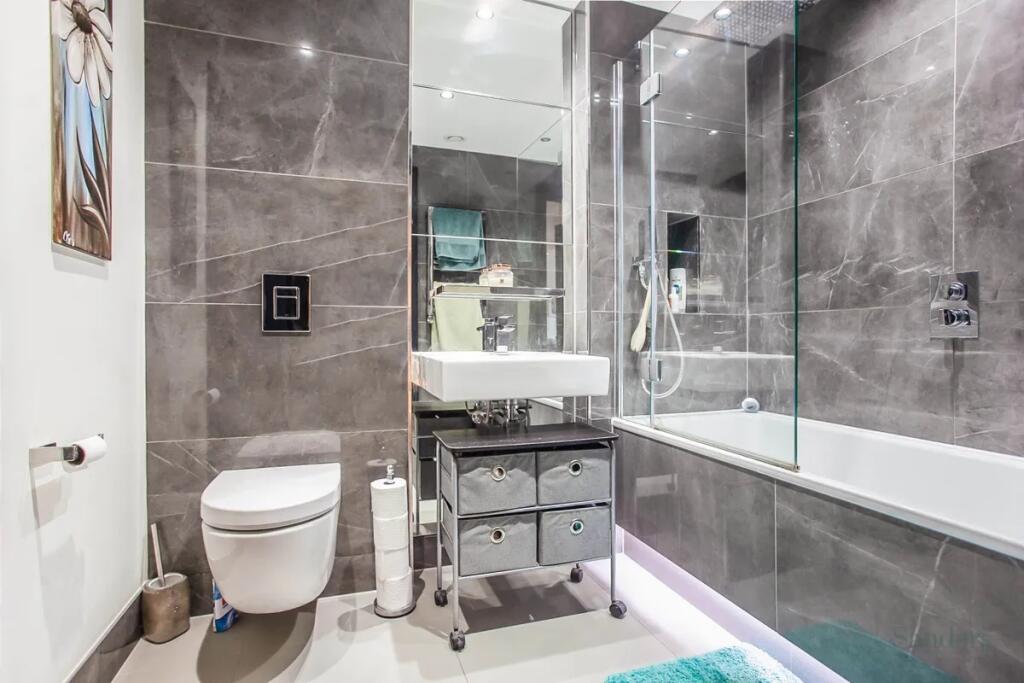 A sleek and modern bathroom suite featuring ele...