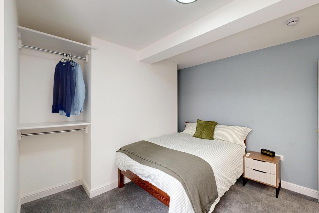 A clean and modern bedroom featuring a comforta...