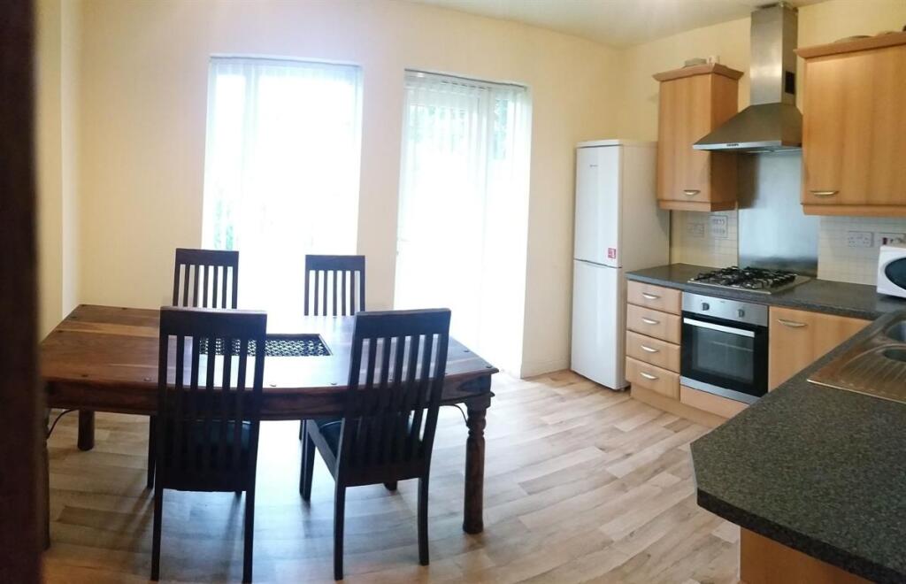 Bright open-plan kitchen with wooden cabinetry,...