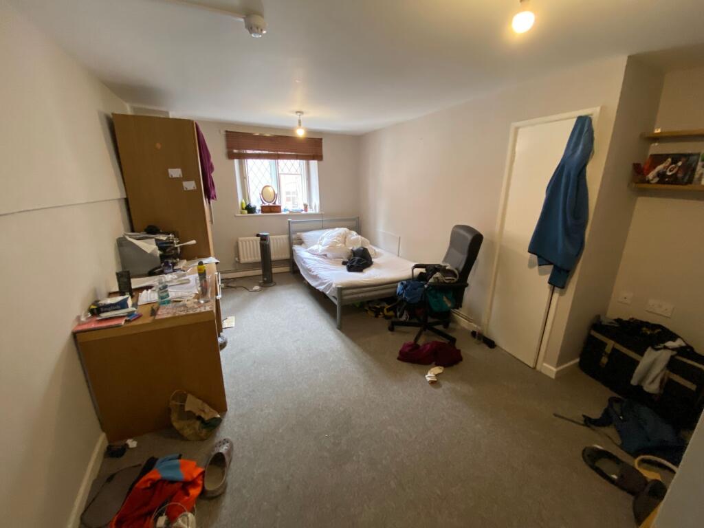 Cozy single bedroom featuring a comfortable bed...