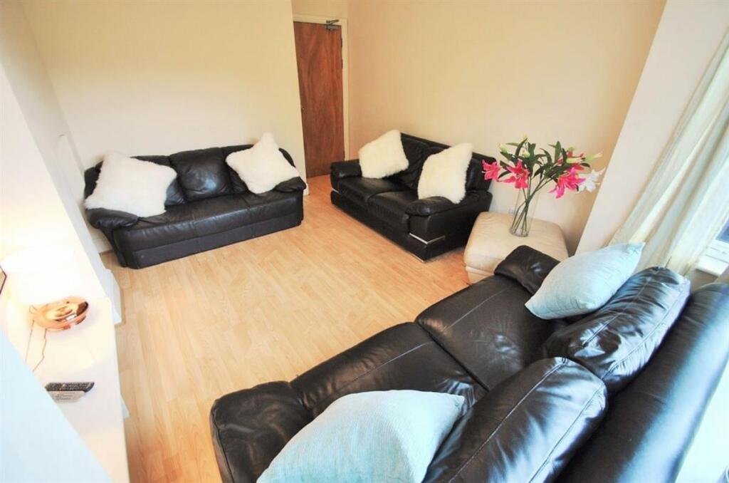 Bright, tidy living room with comfortable black...