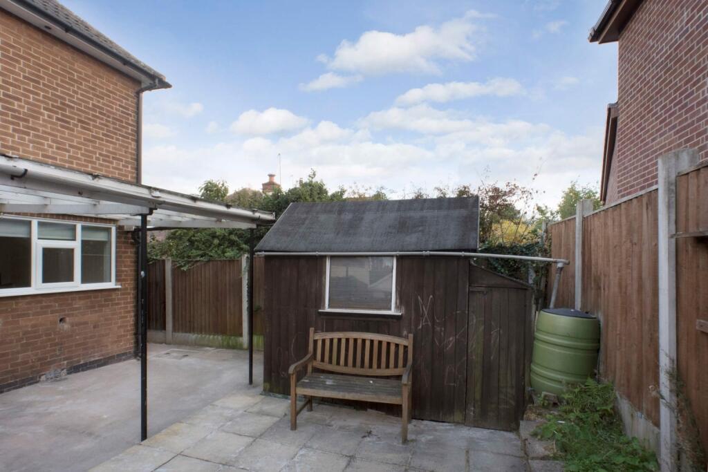 This inviting garden space features a cozy wood...