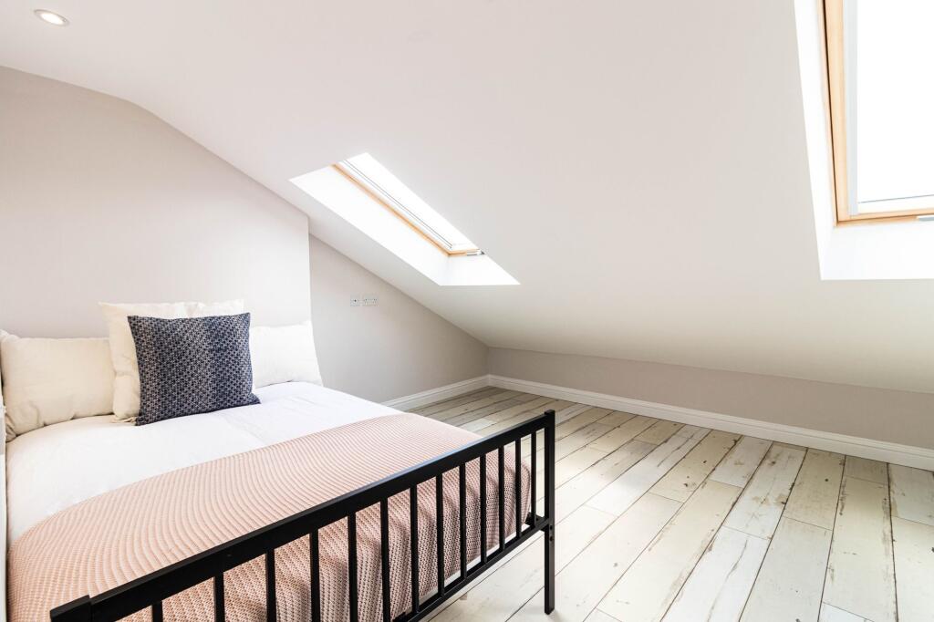 Bright and airy master bedroom featuring a comf...