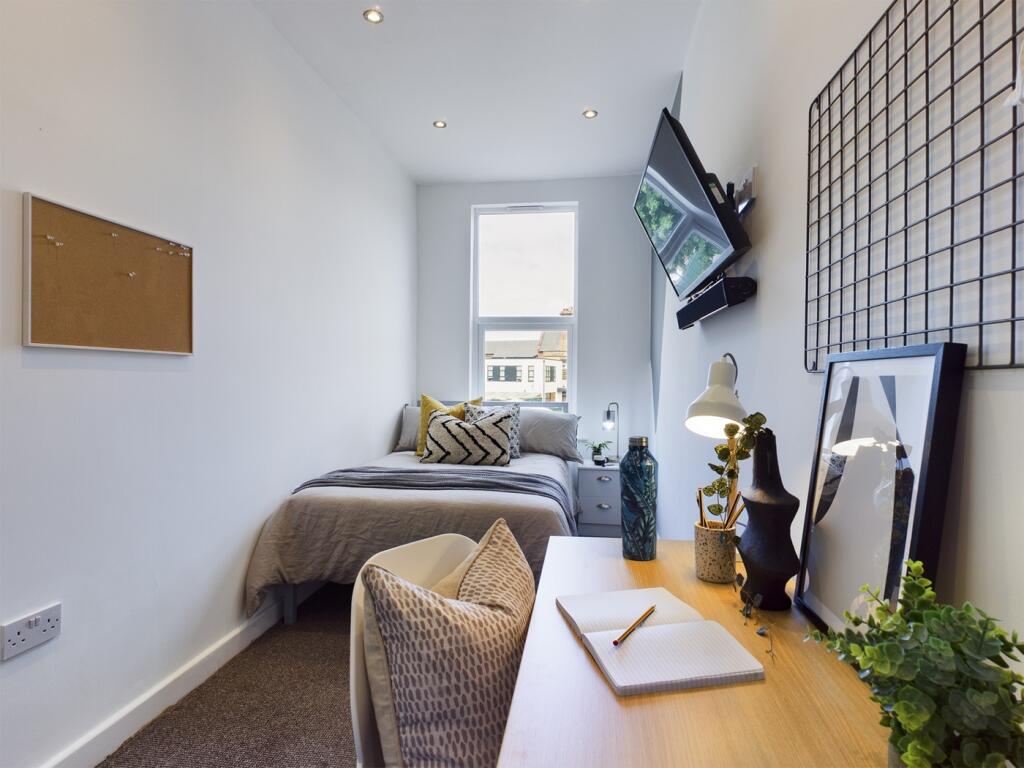 A bright and stylish double bedroom with a cozy...