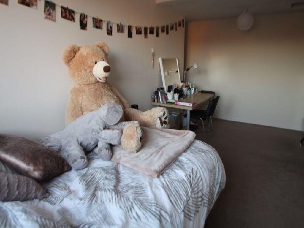 A cozy single bedroom featuring a comfortable b...