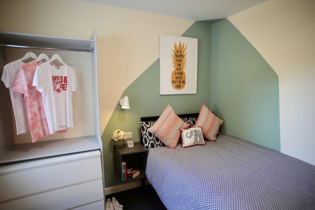 Bright, neatly styled bedroom with a comfortabl...