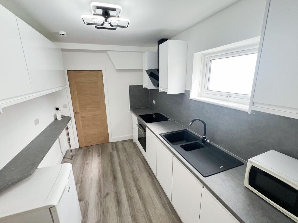 Bright and modern kitchen featuring sleek white...