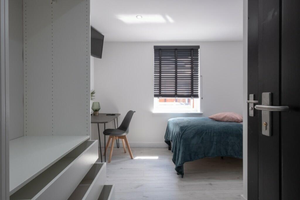 This inviting double bedroom features a cozy be...