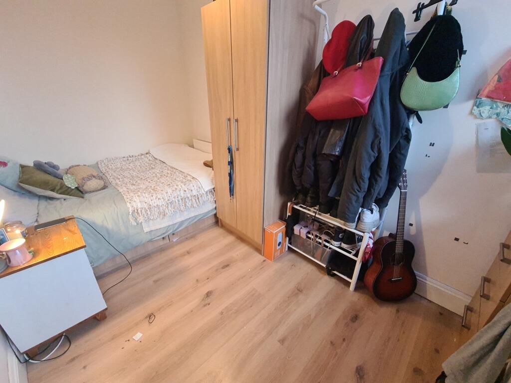 A cozy single bedroom featuring a neatly made b...