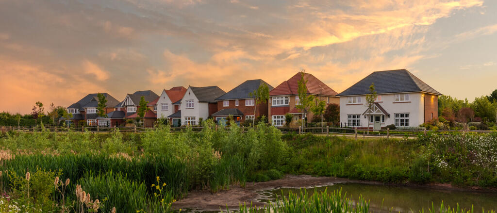 Modern residential houses overlooking a pond and green landscape at sunset, part of Newton Garden Vi