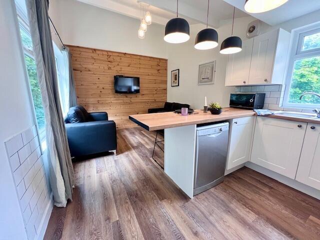 Bright and modern living space featuring wood f...