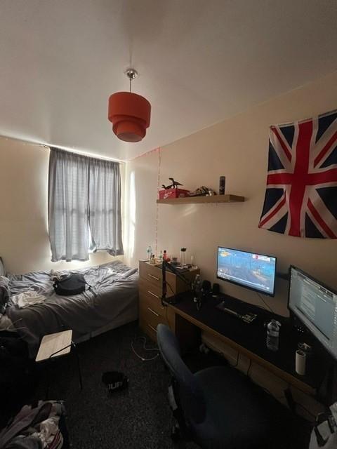 Cozy bedroom with a single bed by the window, a...