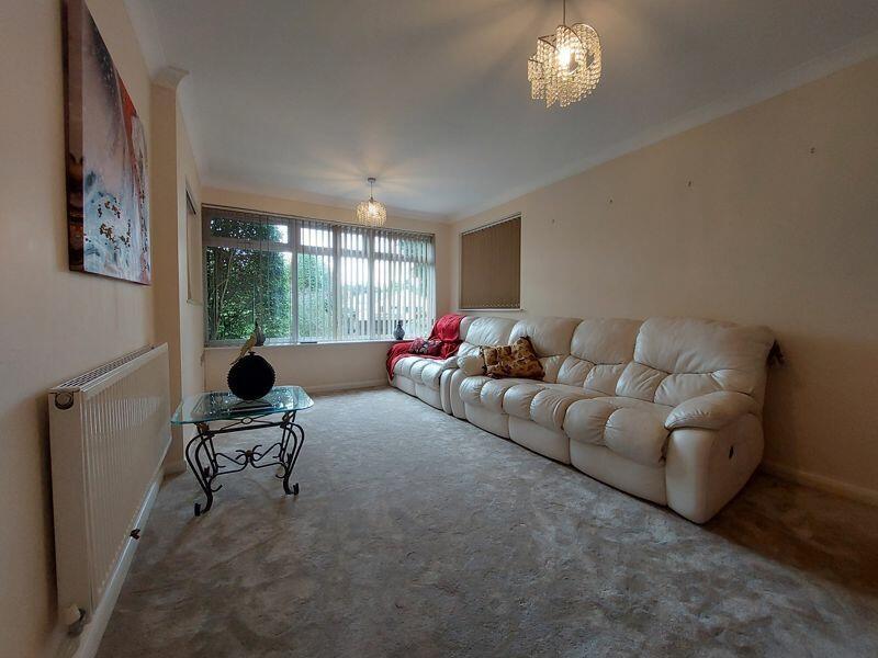 A cozy living room featuring a large cream leat...