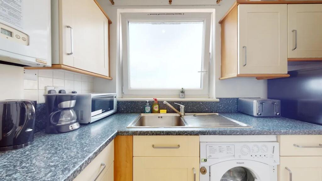 Bright and tidy kitchen featuring modern applia...