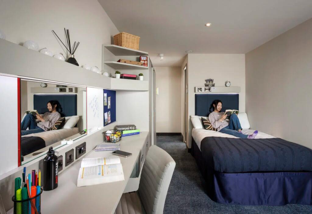 A well-organized single bedroom featuring a com...