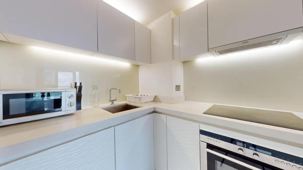 Bright and modern kitchen featuring sleek white...