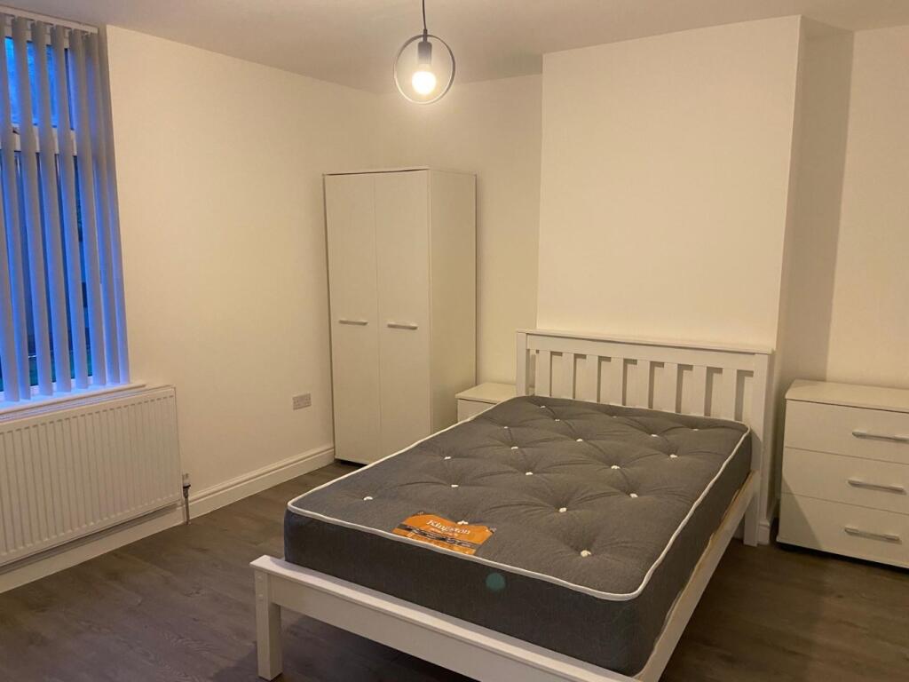 Bright, simply furnished bedroom with a double ...