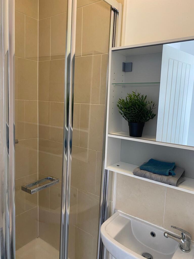 A modern bathroom featuring a sleek shower, ele...