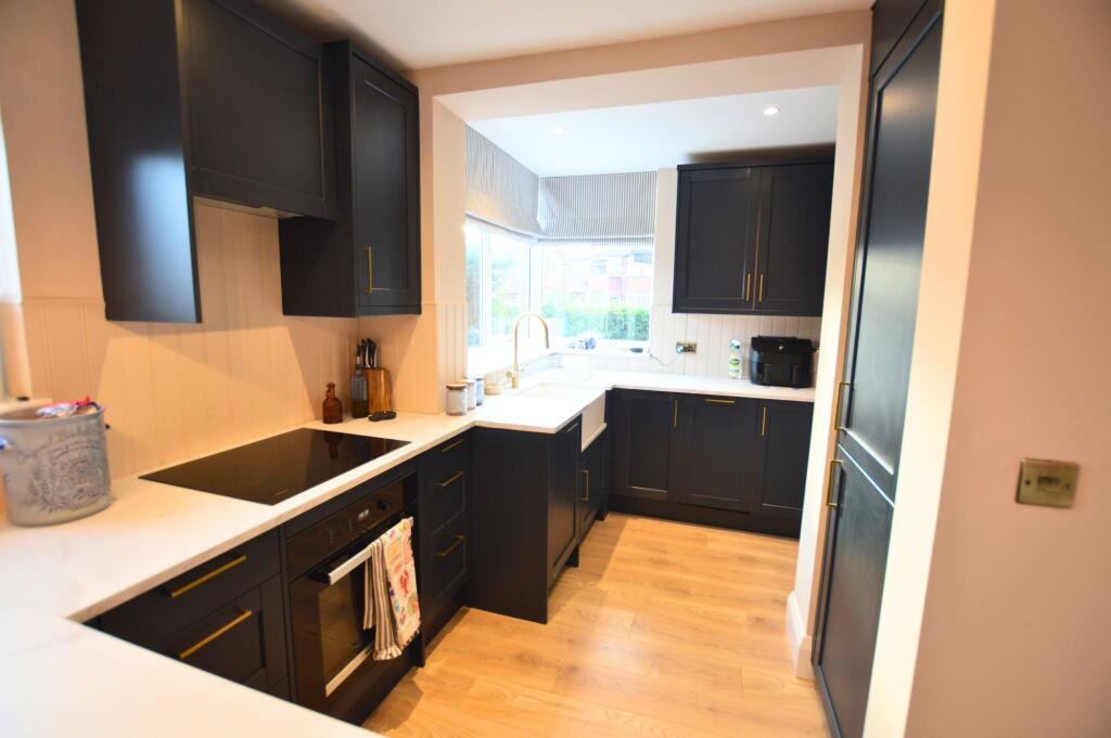 Modern kitchen featuring sleek dark cabinetry c...